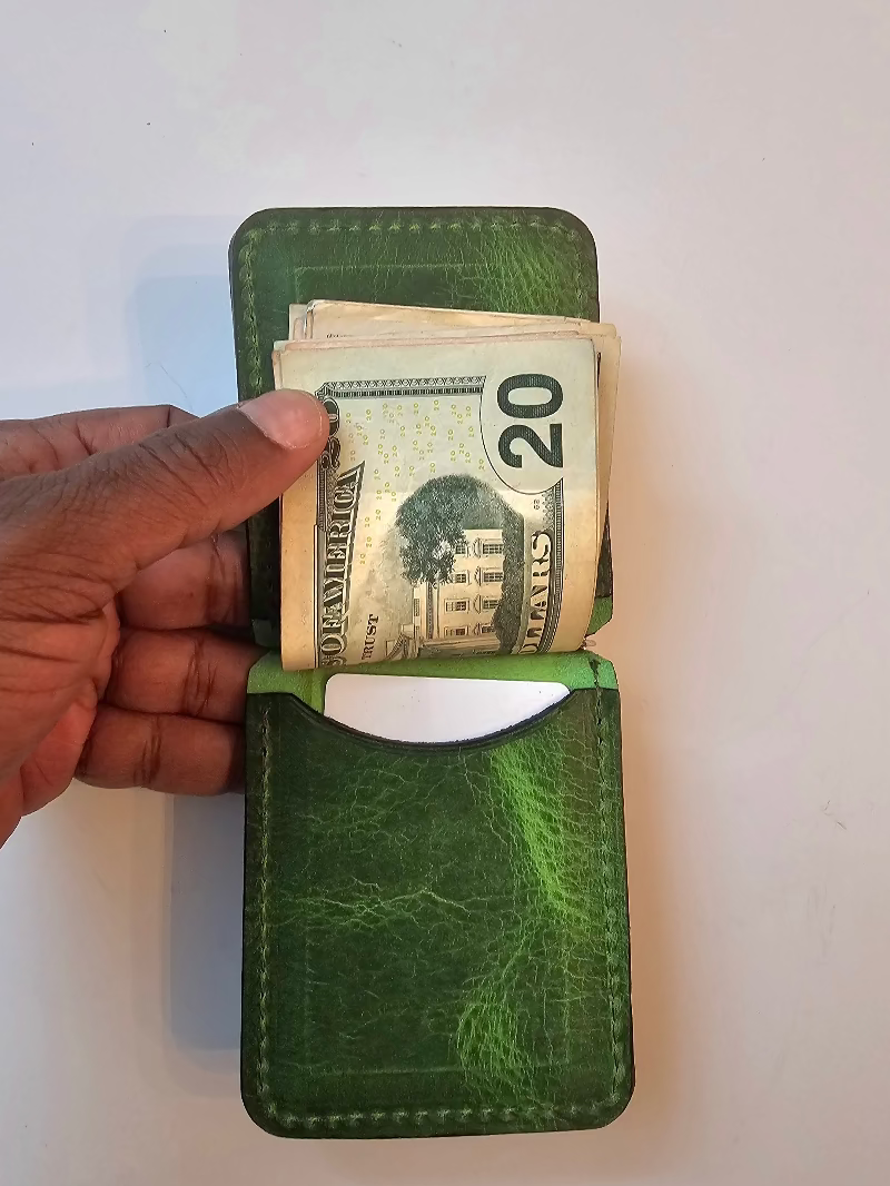 Green wallet with money held by a hand on a white background