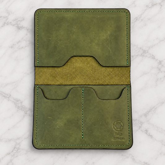 Green Leather Passport Holder on light white and gray marble background