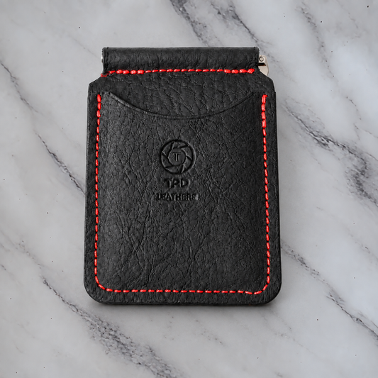 Black and red leather money clip wallet on natural marble background