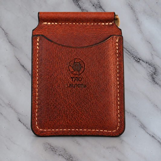 Cognac brown leather money clip wallet on natural marble background