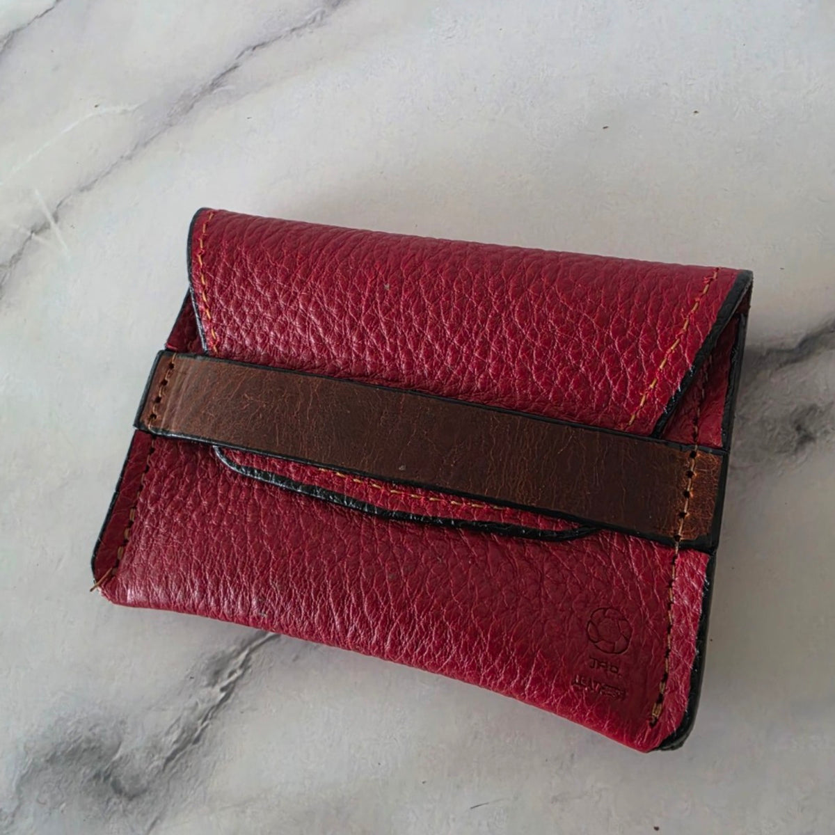 Handmade crimson leather keeper pouch shown at an angle