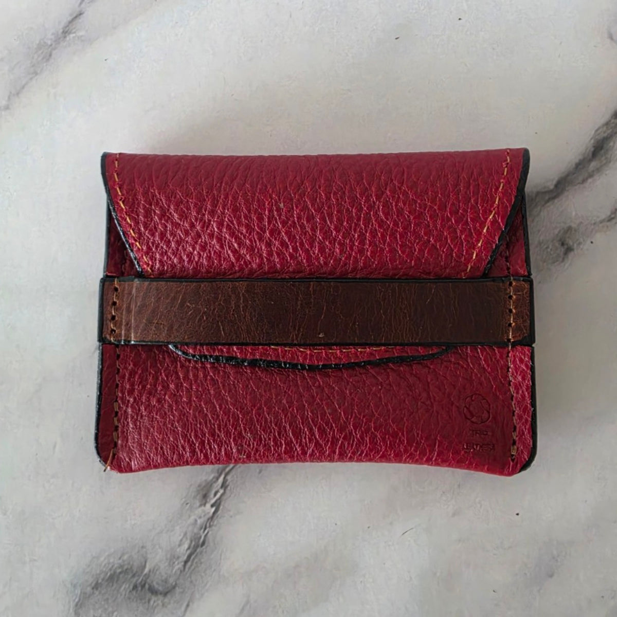 Crimson red pebbled leather keeper pouch with brown leather band, front view