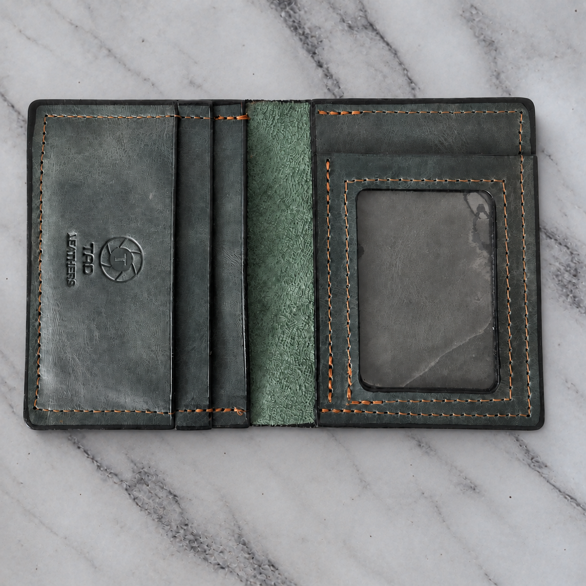 Green charcoal leather ID wallet on natural marble background