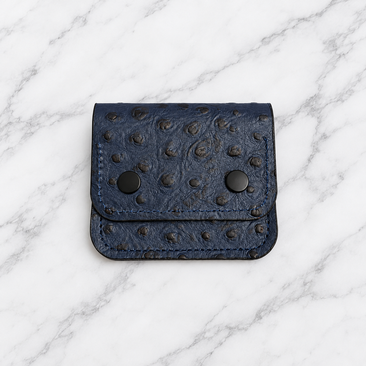 Midnight blue textured leather snap wallet on marble