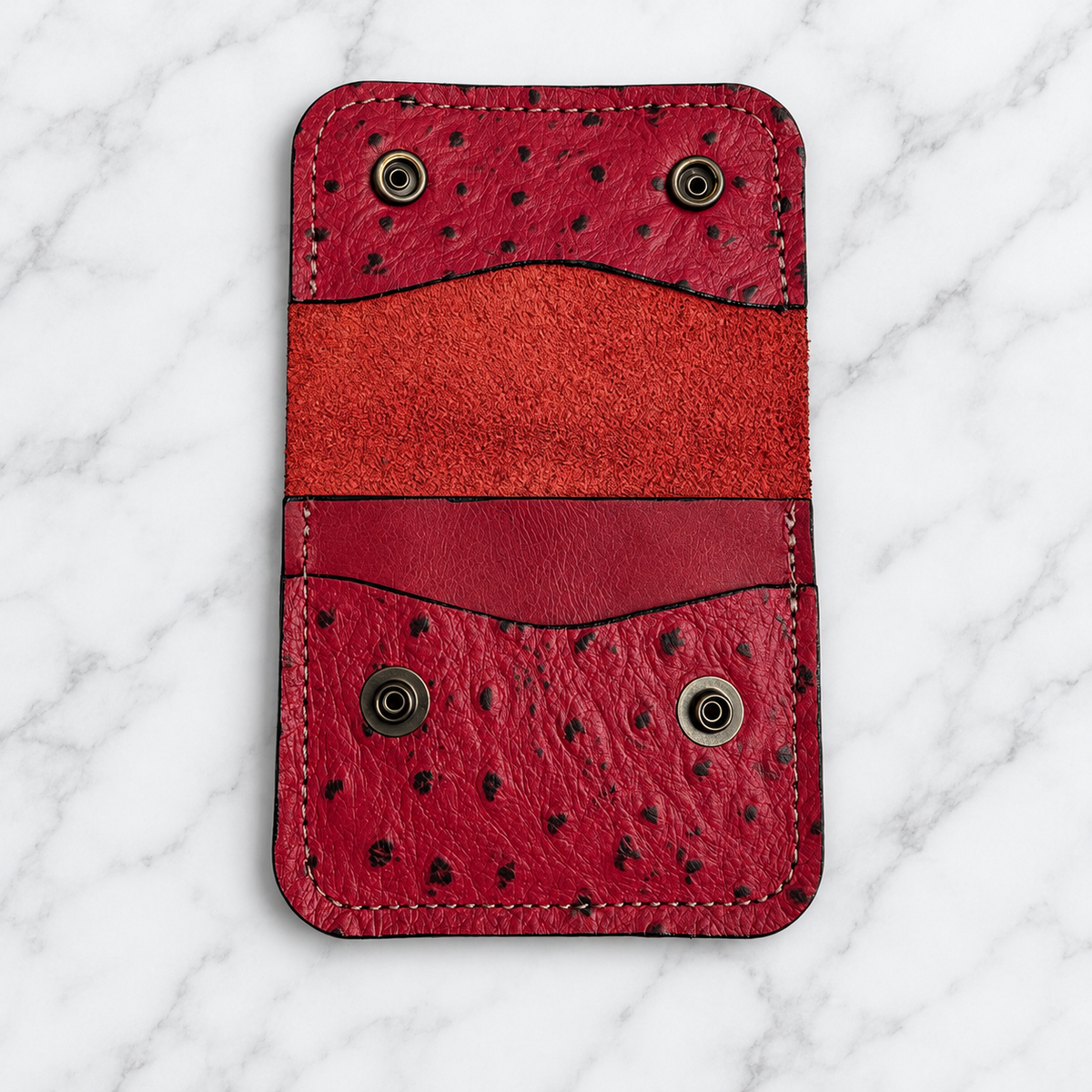 Open ruby red snap wallet interior on marble