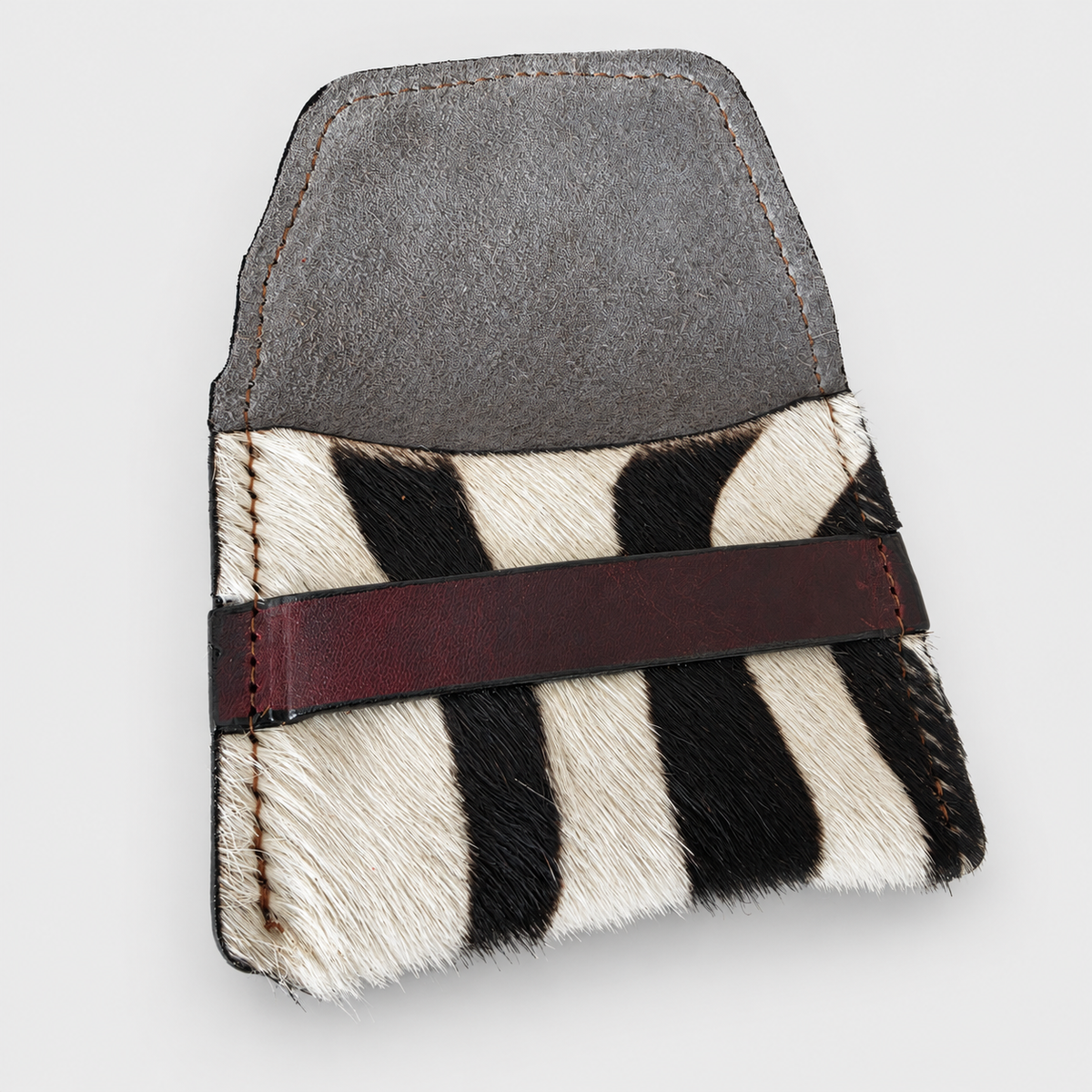 Open zebra-pattern hair-on-hide pouch showing stitching and leather interior