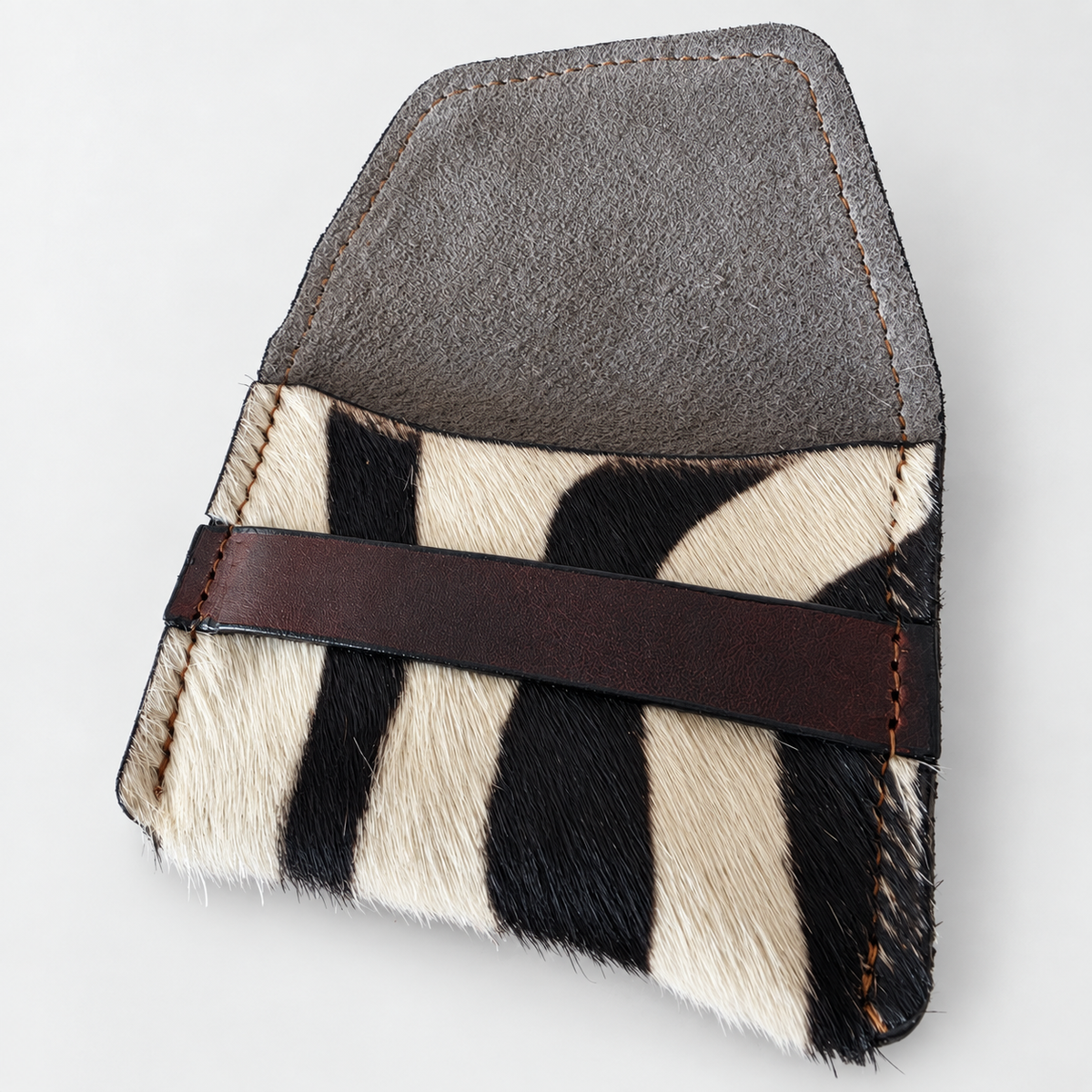 Close view of zebra-pattern hair-on-hide texture and dark brown leather band