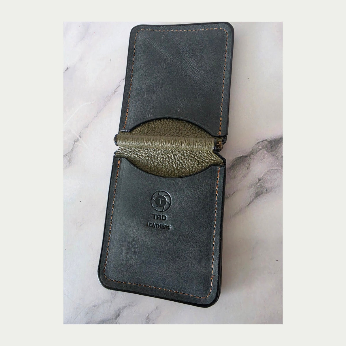 Shadow olive leather spring-bar money clip wallet open with logo upright