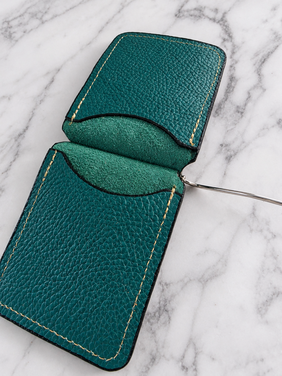Interior detail of teal leather money clip wallet showing pockets and suede texture